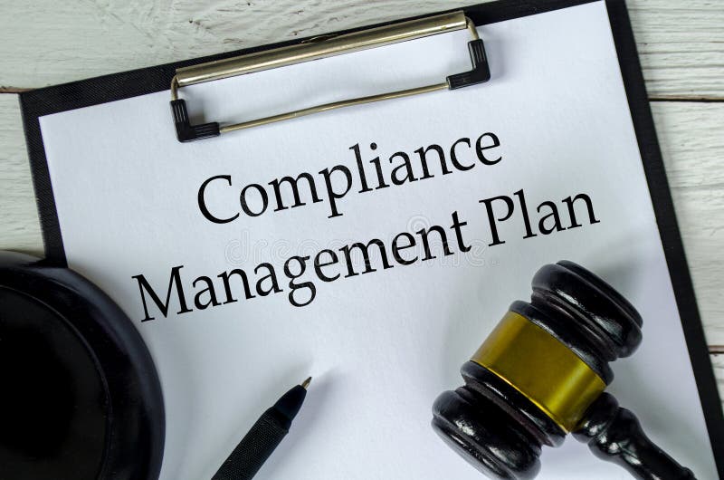 Top view of Compliance Management Plan text on white paper clipboard with gavel stock images
