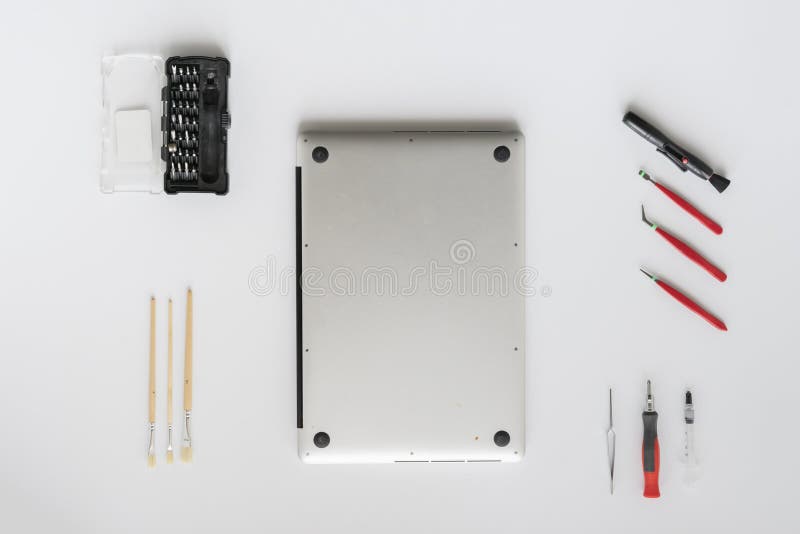 A top view of the computer master in the service fixing the laptop computer on white table stock images