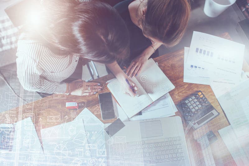 Top view of concentrated young women sitting at the table and working together royalty free stock photos