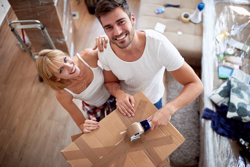 Top view of couple in love while packing things in boxes for moving.  packing, moving, new beginning, concept