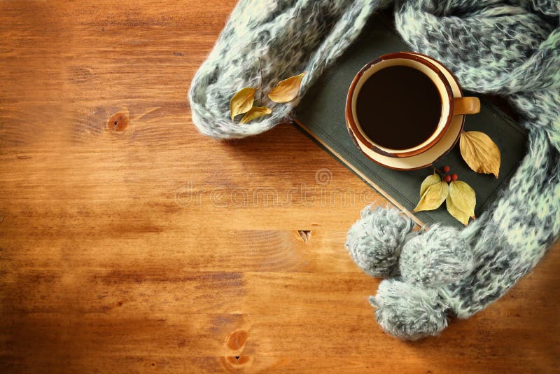 De taza de negro café otono hojas, cálido bufanda viejo un libro sobre el de madera.