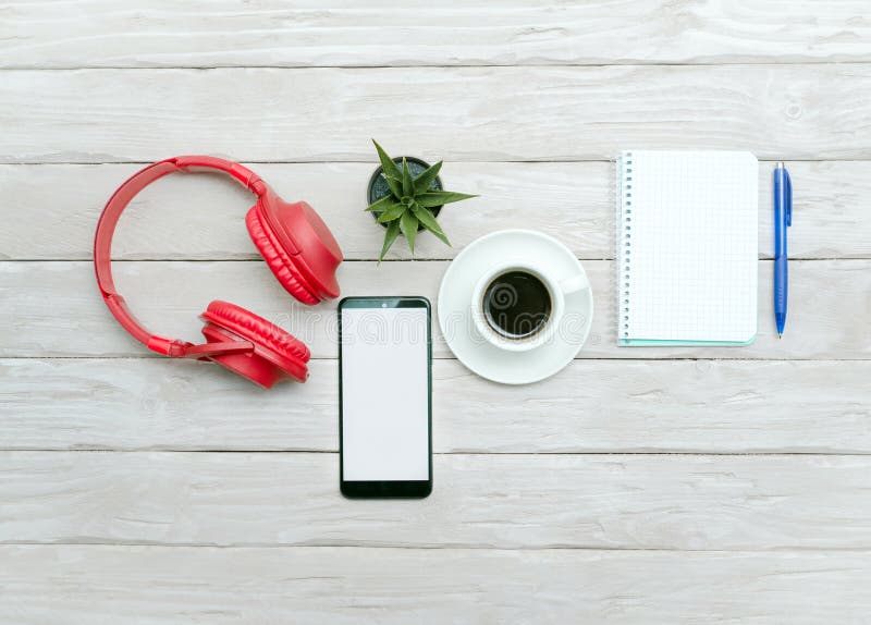 Top view Cup of black coffee, overhead music headphones with notepad with blank page for text. Scheduler. Desktop. Online stock photo