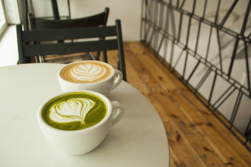 Top view of cup of matcha tea and cappuccino.