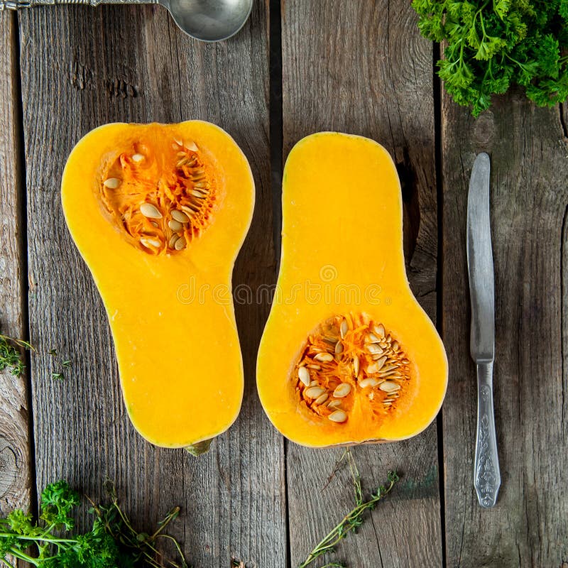 Top view Cut ripe orange pumkin with seeds on the rustic wooden table. Vegetarian, vegan, healthy diet food. Autumn harvest concep