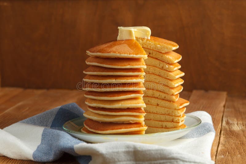 Top view of cut stack of pancake with honey and butter on top. Close up