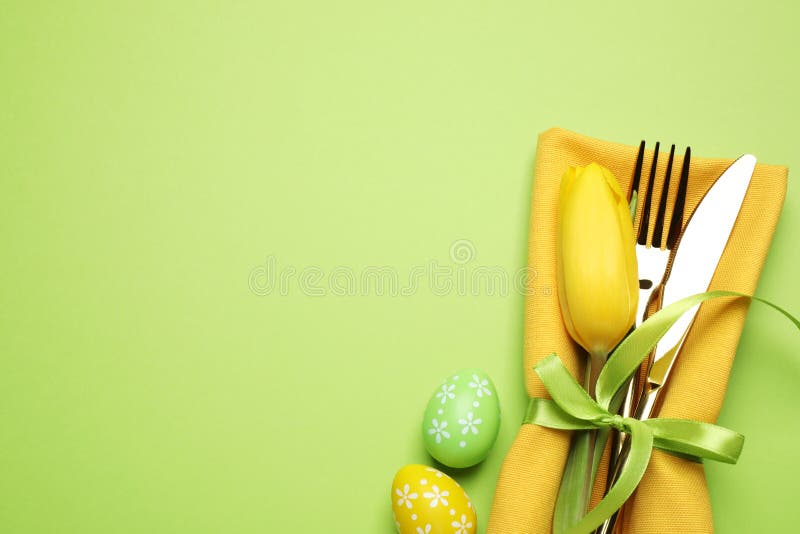 Top view of cutlery set with floral decor on background, space for text. Easter celebration