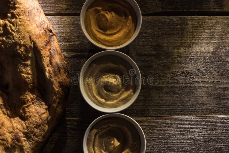 Top view of delicious assorted hummus and fresh baked pita on wooden rustic table. royalty free stock images Top view of delicious assorted hummus and fresh baked pita on wooden rustic table. royalty free stock images
