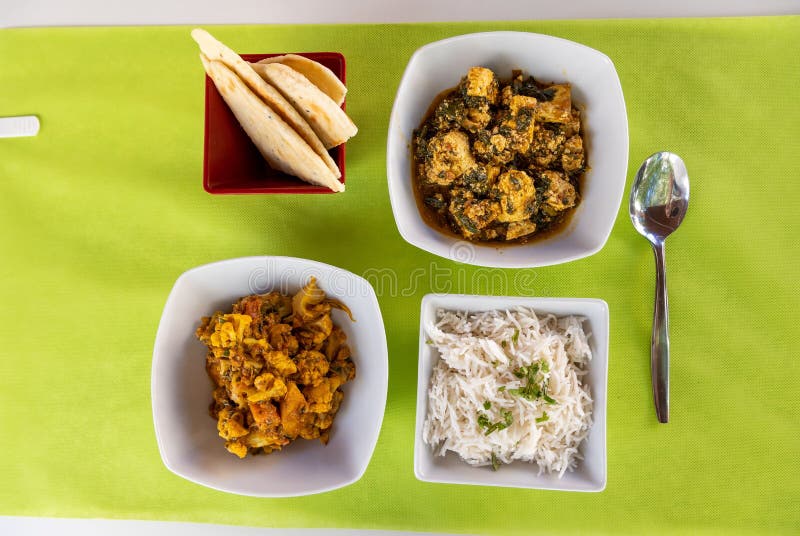 Top View of Different Indian Dishes on White Table with Green