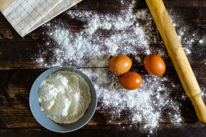 Top View of Eggs, Flour and a Dough Roller on the Table Stock Photo