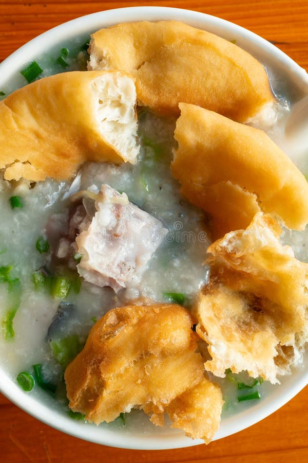 Top view fish porridge with deep-fried Chinese donuts vertical composition royalty free stock photos