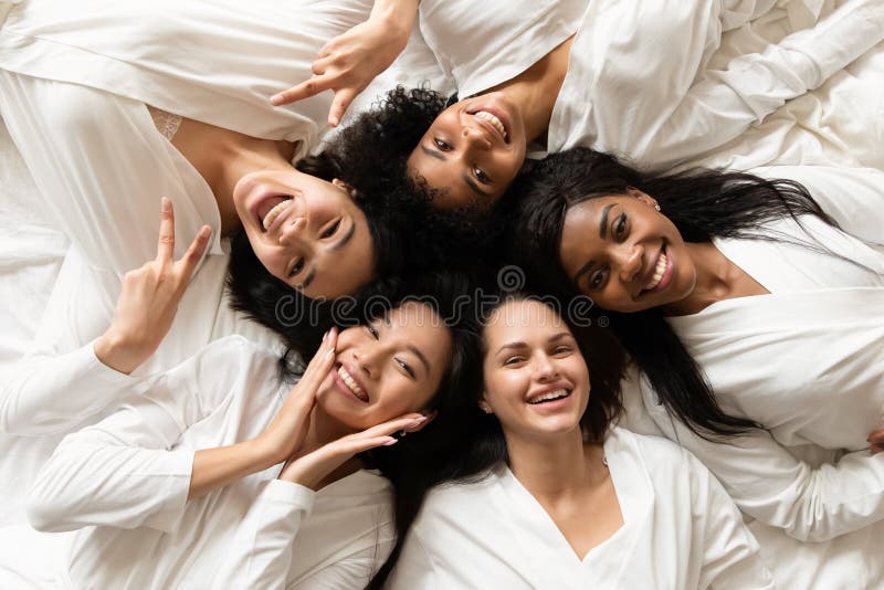 Three glad diverse millennial women in undergarments sit on floor, enjoy  body positivity Stock Photo by Prostock-studio
