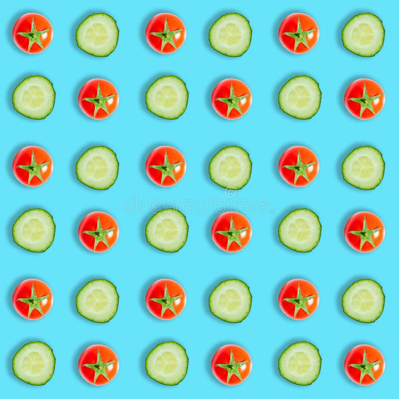 Top view of cucumber slices and red cherry tomatoes isolated on blue background