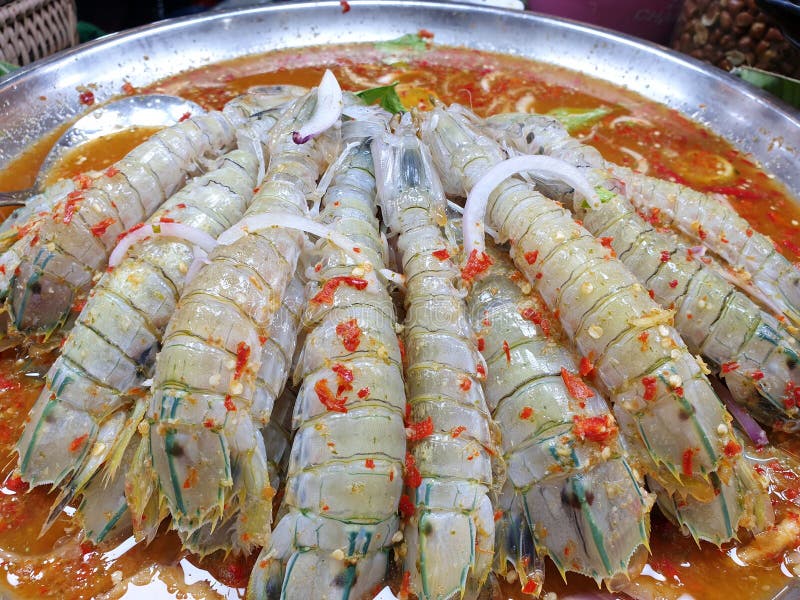 Top view of fresh mantis shrimp topped with spicy seafood dipping sauce for sale in the restaurant at Thailand