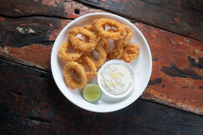 Fried Calamari Rings with Dip Sauce on Rustic Wooden Table Stock Photo