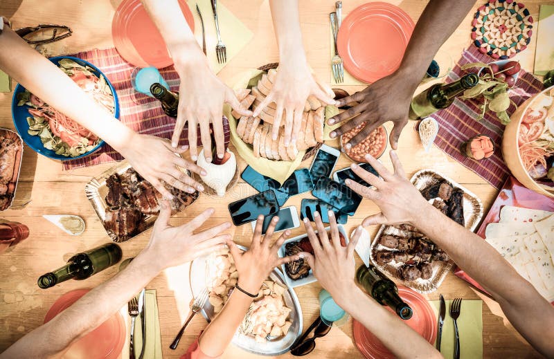 Top view of friend hands on food with mobile smart phones. Top view of friend hands with mobile smart phones at barbecue garden party - Multiracial people group royalty free stock photos