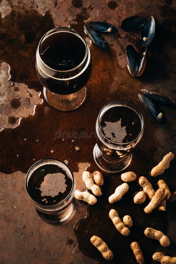 top view of glasses of cold beer peanuts and mussels shells royalty free stock photography