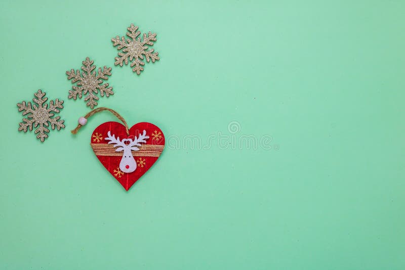 Top view of glittery snowflakes and a red dekoration for christmas isolerad på den gröna bakgrunden fotografering för bildbyråer