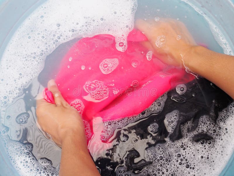 Top view of soaking colored clothes in laundry detergent water