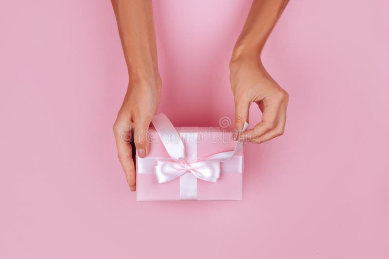 Top view hand woman holding brown gift box on pink pastel color background stock photography Top view hand woman holding brown gift box on pink pastel color background stock photography