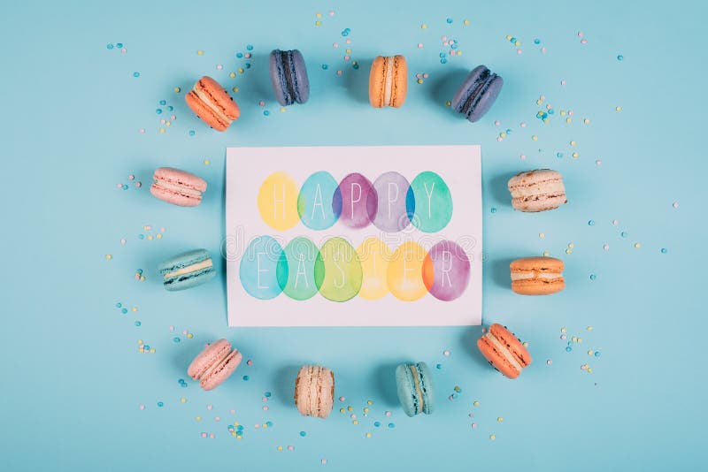 Top view of happy easter greeting card with colorful macarons around