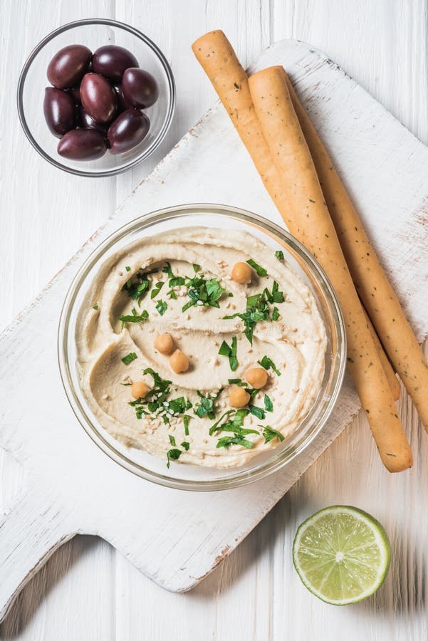 Top View of Hummus with Parsley Breadsticks Olives and Lime Stock Image ...