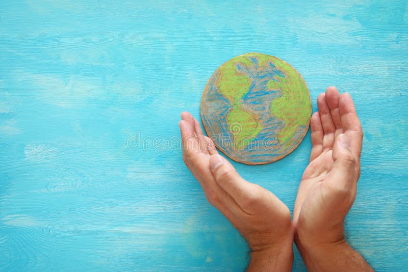 Top view image of man hands holding earth globe over blue wooden background. royalty free stock images Top view image of man hands holding earth globe over blue wooden background. royalty free stock images