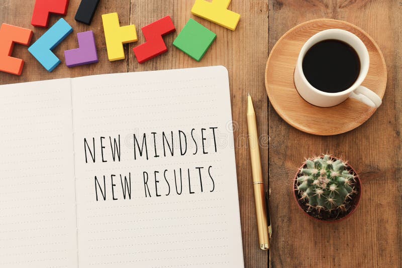 Top view image of table with open notebook and the text new mindset new results. success and personal development concept stock images Top view image of table with open notebook and the text new mindset new results. success and personal development concept stock images