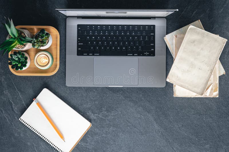 Top view, laptop, notebook and books on a dark background. stock photo