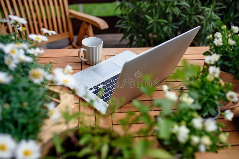 Top view of laptop on table on balcony in summer, outdoors office concept.