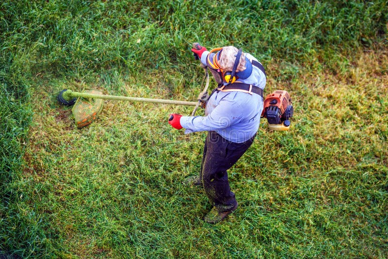 Top View Lawnmover Man Worker Cutting Dry Grass with Lawn Mower Stock