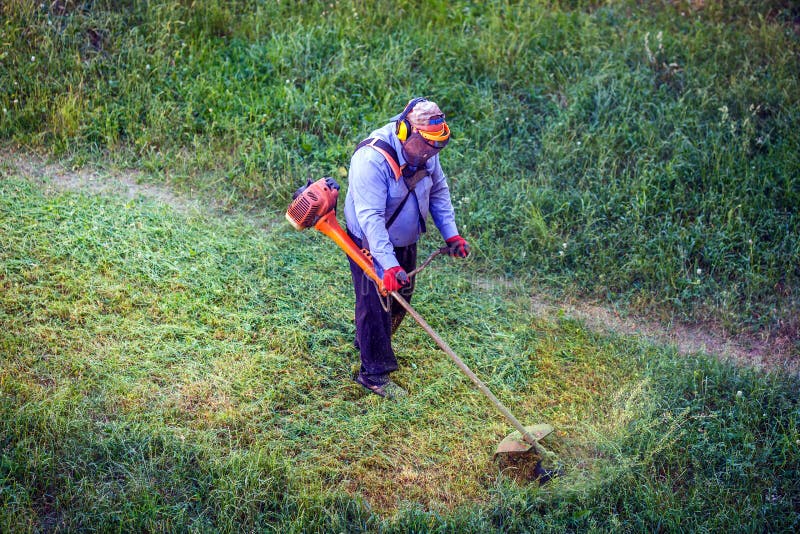 Top View Lawnmover Man Worker Cutting Dry Grass with Lawn Mower Stock