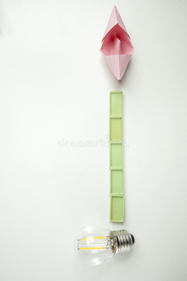 Top view of a lightbulb with rectangular blocks and paper sailboat on white background concept travel exploration navigation imagens de stock royalty free