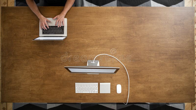 Top view. Male hands working on laptop on empty wooden table in coworking space. Two computers on the table royalty free stock photos