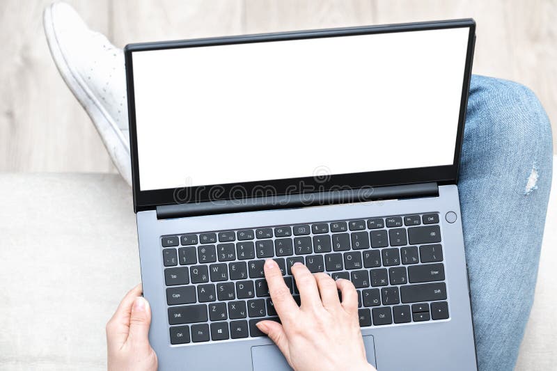 Top view mockup image of woman holding laptop with blank white screen. woman using notebook with while sitting cross-legged on stock photography
