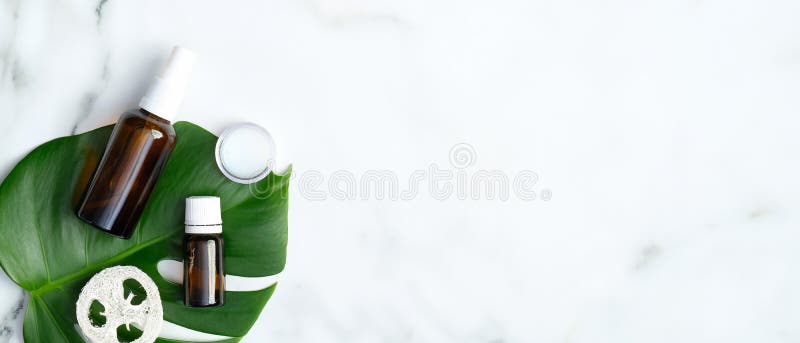 Top view natural organic SPA cosmetic products set with monstera tropical plant leaf on marble background. Skin care and beauty