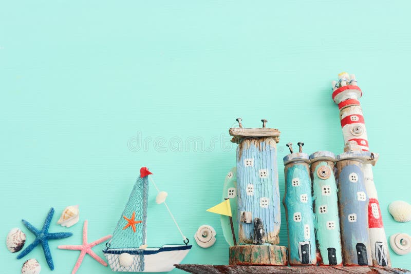 Top view of Nautical concept with sea life style objects as boat, driftwood beach houses, seashells and starfish over wooden