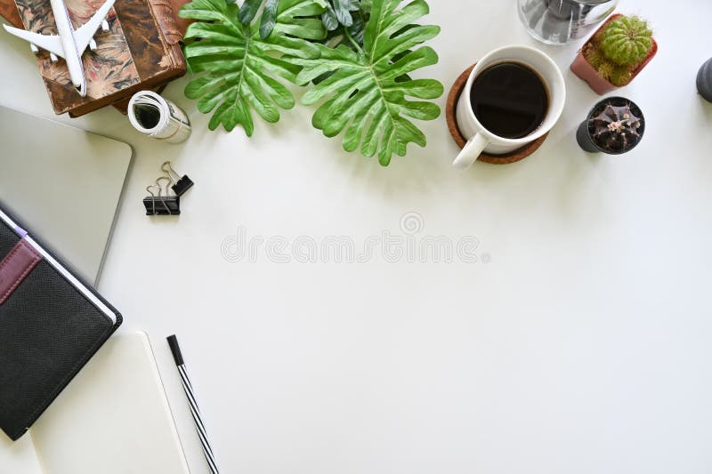 Top view office desk with coffee, books, laptop and cactus on white table