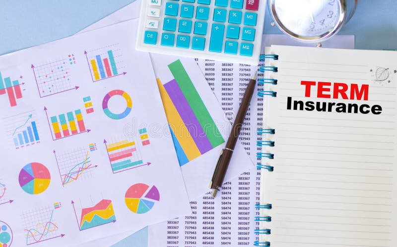 Top view of an office desk table with analysis chart papers and &x22;term insurance&x22; word on a notebook