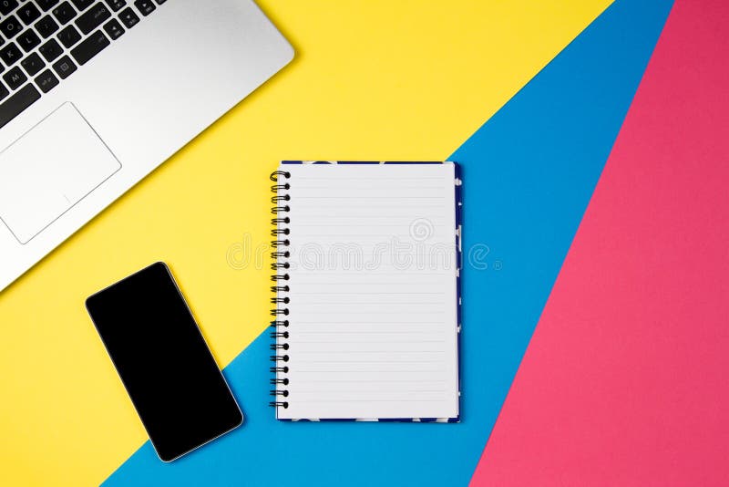 Top view office table desk. Workspace with laptop, smartphone and open spiral notebook page on colorful background. stock photos Top view office table desk. Workspace with laptop, smartphone and open spiral notebook page on colorful background. stock photos