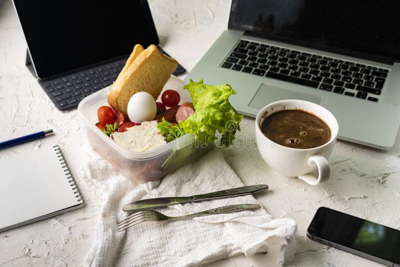 Top view of the office work place with computer or laptop pen and phone, nutritious lunch during the works royalty free stock image