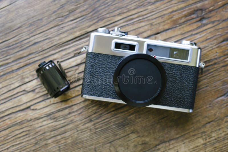 Top View of Old Film Camera with Lens Cap and Roll of Film Stock Image
