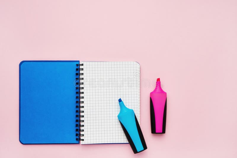 Top view of an open notebook with blank squared pages and felt tip pens. School notebook on a pink background, spiral notepad. royalty free stock images Top view of an open notebook with blank squared pages and felt tip pens. School notebook on a pink background, spiral notepad. royalty free stock images