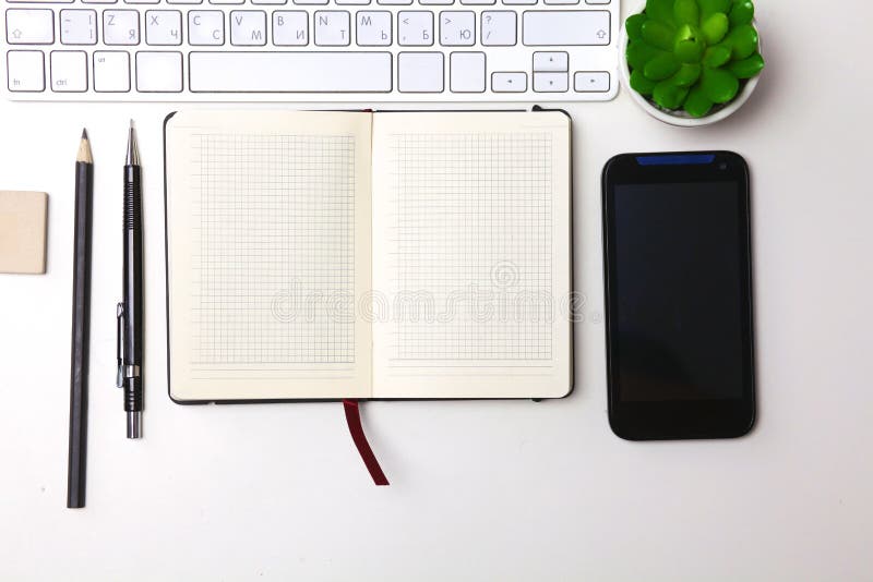 Top view open notebook, pencil and plant potted on white desk background