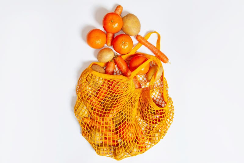 Top View of an Orange Mesh Grocery Bag with Vegetables Isolated on a