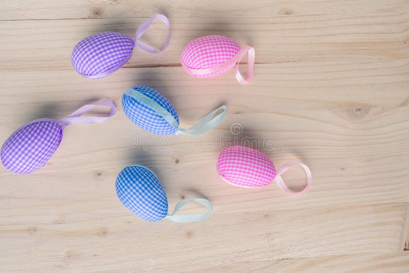 Top view of pink and blue checkered Easter eggs decorations on pale wooden background stock image Top view of pink and blue checkered Easter eggs decorations on pale wooden background stock image