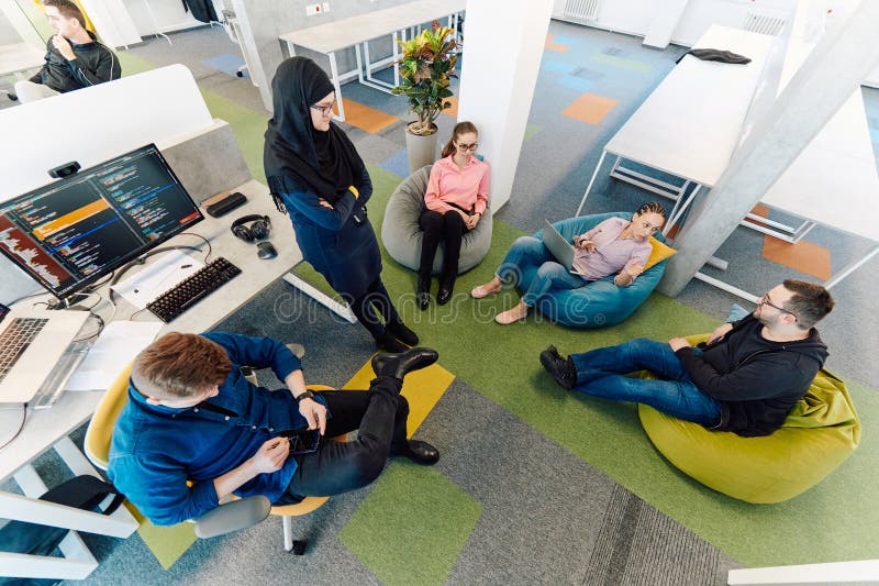 Top view photo of collaborative process of multicultural skilled young business team during brainstorming meeting in stock photography