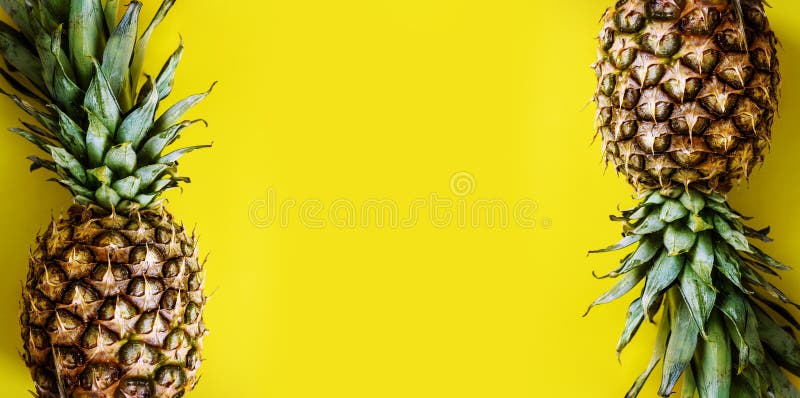 Top view of pineapple border on bright yellow background. Vivid pastel layout with ananas frame from above