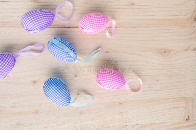 Top view of pink and blue checkered Easter eggs decorations on pale wooden background royalty free stock image Top view of pink and blue checkered Easter eggs decorations on pale wooden background royalty free stock image