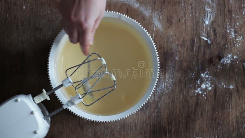 Top view of pours a glass of cream in the dough