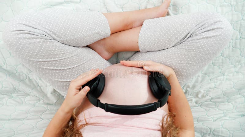 Pretty Pregnant Woman Putting Headphones On Her Belly Stock Photo, Picture  and Royalty Free Image. Image 59147162.